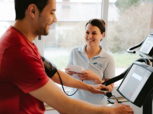 Ein Mann bei einer Behandlung auf einem Fitnessgerät im Biohotel Eggensberger in Hopfen am See / Füssen