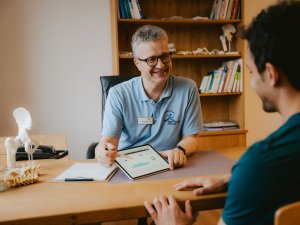 Ein Mann erhält eine Analyse gezeigt im Biohotel Eggensberger in Hopfen am See / Füssen