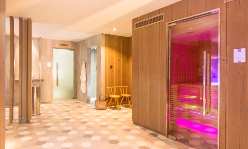 Einblick in den Spa Bereich im Hotel Hahnenköpfle in Oberstdorf mit Blick auf eine Sauna und dem breiten Durchgang