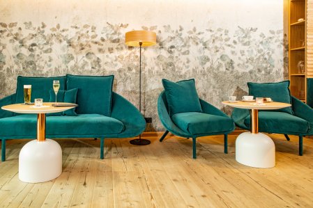 Einblick in eine Lounge im  Hotel Hahnenköpfle in Oberstdorf mit gemütlichen und stilvollen Sitzgelegenheiten und kleinen Tischen vor ihnen