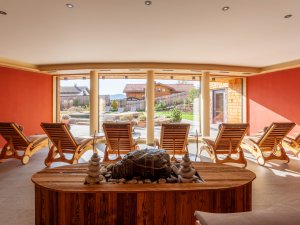 Einblick in den Ruheraum im Biohotel Eggensberger in Hopfen am See / Füssen mit gemütlichen Liegen vor einer breiten Fensterreihe