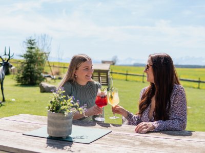 Freundinnen genießen einen Aperitif auf der Terrasse des Weitblick Allgäu in Marktoberdorf.