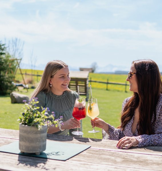 Freundinnen genießen einen Aperitif auf der Terrasse des Weitblick Allgäu in Marktoberdorf.