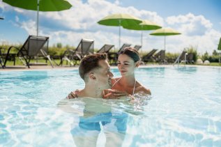 Ein Paar entspannt sich im Außenpool im Weitblick Allgäu in Marktoberdorf.