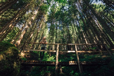 Eine Dame wandert durch den Wald in der Nähe des Torgheles Wald & Fluh in Balderschwang.