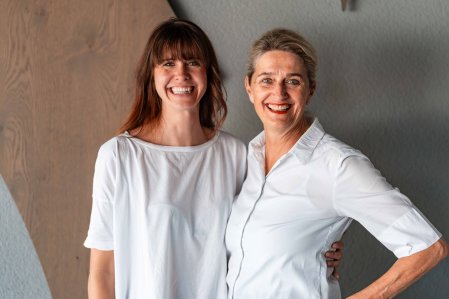 Die beiden Hotelführerinnen vom Hotel Franks in Oberstdorf stehen nebeneinander und lachen in die Kamera