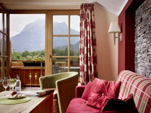 Einblick in eines der Zimmer im Hotel Sommer mit Balkon und schöner Aussicht sowie gemütlichen Sitzgelegenheiten