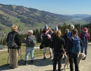Eine Gruppe von Wanderern begutachtet die Aussicht in den Bergen beim Parkhotel Oberstaufen in Oberstaufen.