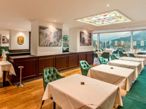 Der Regentensaal mit grünen Stühlen und weißen Tischen im Hotel Prinz-Luitpold-Bad in Bad Hindelang.