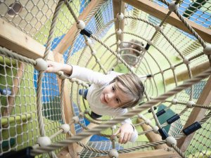 Ein kleiner Junge klettert das Klettergerüst im Indoorspielplatz des Familotel Allgäuer Berghof in Gunzesried hoch.