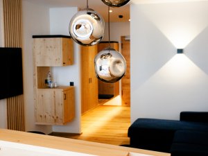 Ein Zimmer mit silberner Hängelampe und modernen Holzmöbeln im Bio-Berghotel Ifenblick in Balderschwang.
