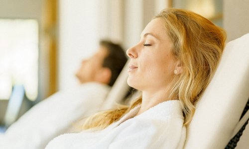 Eine Dame entspannt im Bademantel im Wellnessbereich des Landhotel Gockelwirt in Eisenberg.