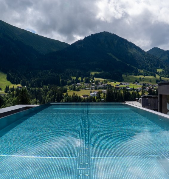 Außenpool mit Aussicht des Genuss & Aktivhotel Sonnenburg in Riezlern.