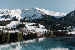 Der Außenpool mit winterlicher Aussicht des Genuss & Aktivhotel Sonnenburg in Riezlern.