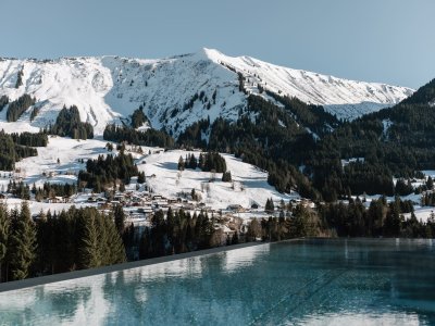 Der Außenpool mit winterlicher Aussicht des Genuss & Aktivhotel Sonnenburg in Riezlern.