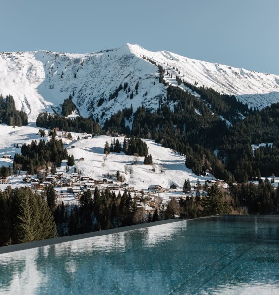 Der Außenpool mit winterlicher Aussicht des Genuss & Aktivhotel Sonnenburg in Riezlern.