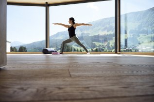 Eine Frau macht Yoga mit Aussicht im Genuss & Aktivhotel Sonnenburg in Riezlern.