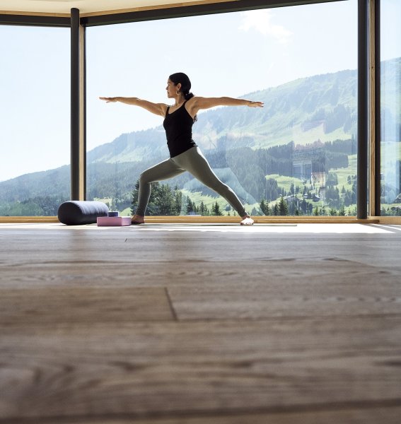Eine Frau macht Yoga mit Aussicht im Genuss & Aktivhotel Sonnenburg in Riezlern.