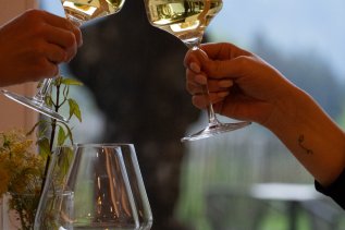 Im Restaurant des Kühberg - Das Hotel über Oberstdorf in Oberstdorf wird mit Weißwein angestoßen.