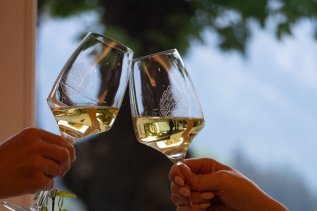 Im Restaurant des Kühberg - Das Hotel über Oberstdorf in Oberstdorf wird mit Weißwein angestoßen.