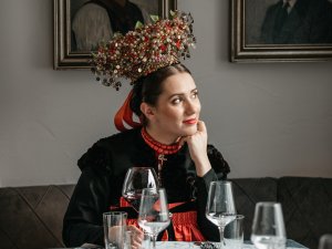 Eine traditionell gekleidete Frau sitzt an einem Tisch im Restaurant des Hotel Tradizio in Mittelberg.