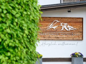 Das Hotelschild des Hartungs Hoteldorf in Hopfen am See.