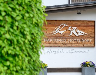 Das Hotelschild des Hartungs Hoteldorf in Hopfen am See.