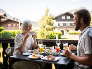 Ein Paar beim Frühstück auf der Terrasse des Freiberg Romantik Hotel in Oberstdorf.