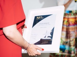 Eine Person vom Hotel Franks hält eine Auszeichnung in der Hand