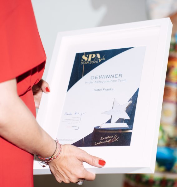 Eine Person vom Hotel Franks hält eine Auszeichnung in der Hand