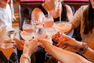 Personen stoßen mit Drinks im Hotel Bannwaldsee in Halblech gemeinsam an