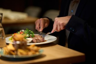 Ein Gast isst im Restaurant im Hotel Bannwaldsee in Halblech