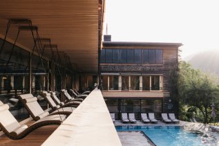 Blick auf Schwebeliegen am Pool des Naturhotel Chesa Valisa im Kleinwalsertal.