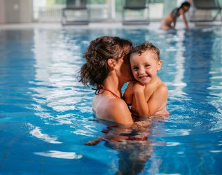 Eine Mutter und ihr Kind im Innenpool des Mondi Resort Oberstaufen in Oberstaufen.