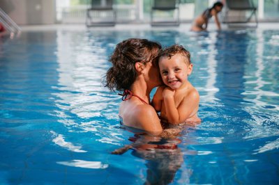 Eine Mutter und ihr Kind im Innenpool des Mondi Resort Oberstaufen in Oberstaufen.