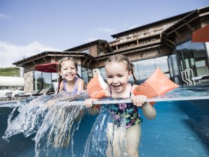 Kinder beim Planschen im Außenpool im Familotel Allgäuer Berghof in Gunzesried