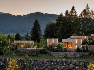 Außenansicht der Naturlodges im Sonnenalp Resort in Ofterschwang mit Abendstimmung