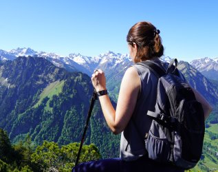 Eine Dame beim Wandern in den Bergen in der Nähe des Hotel Kühberg in Oberstdorf.