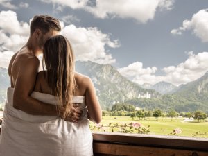 Ein Paar genießt die Aussicht vom Balkon des Hotel Das Rübezahl in Schwangau.