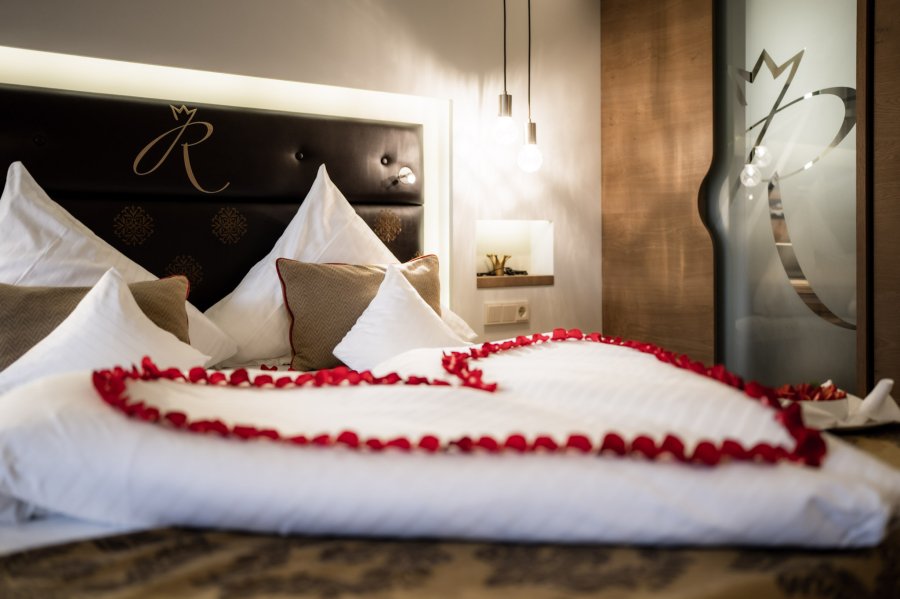 Ein Bett mit Rosen in einer Herzform in einem Zimmer des Hotel Das Rübezahl in Schwangau.