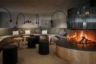 Blick auf die Lounge mit Kamin in der Kraftquelle Fanny in Maierhöfen.