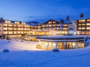 Außenansicht des Schüle's Gesundheitsresort & SPA in Oberstdorf an einem Winterabend mit Blick auf das erleuchtete Hotelgebäude