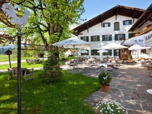 Blick auf den Garten und einen Teil des Hotelgebäudes des Landhotel Gockelwirt in Eisenberg im Sommer