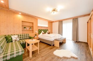 Einblick in eines der gemütlichen, mit Holz ausgekleideten Zimmer im Hotel Garni Schellenberg in Oberstdorf