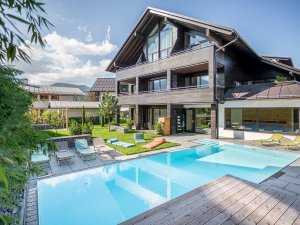 Die Außenansicht des Freiberg Romantik Hotels in Oberstdorf mit Pool im Sommer.
