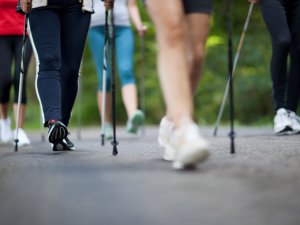 Eine Gruppe von Gästen macht eine Nordic Walking Tour durch den Wald in der Umgebung des Rosenalp Gesundheitsresorts und Spa in Oberstaufen