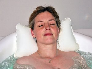 Eine Frau entspannt sich bei einem Wellnessbad im Hotel Allgäu Sonne in Oberstaufen.