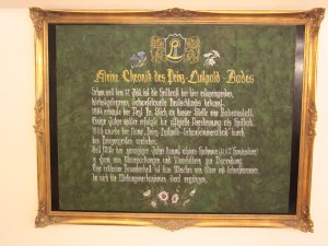 Eine Tafel mit goldenem Rahmen mit der Geschichte des Hotels Prinz-Luitpold-Bad in Bad Hindelang.