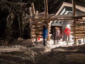 Gäste an einem Winterabend vor dem Haubers Naturresort in Oberstaufen.