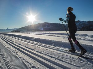 Eine Frau beim Langlaufen an einem sonnigen Wintertag in der Umgebung des Wellnesshotels Mittelburg in Oy-Mittelburg